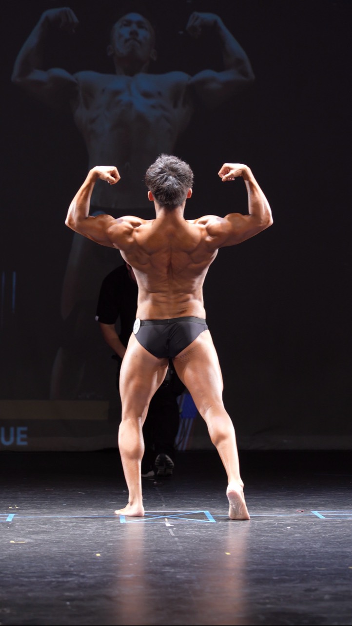 ZT Li performing a back double biceps pose on stage